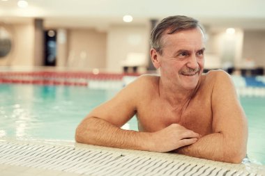 Portrait of modern senior man enjoying swimming pool while relaxing at luxury SPA resort, copy space clipart