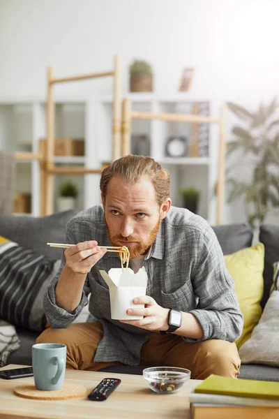 Portret Smutnego Mężczyzny Średnim Wieku Jedzącego Makaron Wynos Oglądając Telewizję — Zdjęcie stockowe