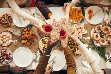 Top view background of people raising glasses over festive dinner table while celebrating Christmas with friends and family, copy space clipart
