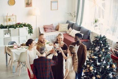 Noel partisinin tadını çıkaran ve güzel yemek odasında şampanya içen zarif insanlardan oluşan yüksek açılı bir manzara.