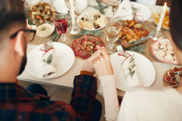 圣诞期间 人们围坐在餐桌前 手拉手一起祈祷 复印空间 请看上图 — 图库照片