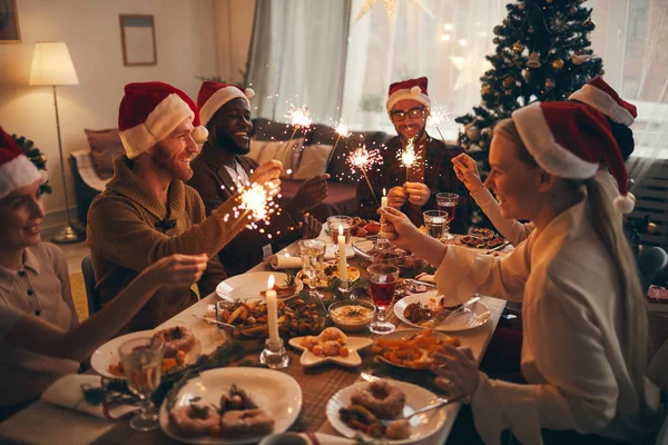 Multi Ethnic Group People Holding Sparklers While Enjoying Christmas Dinner — Stock Photo, Image