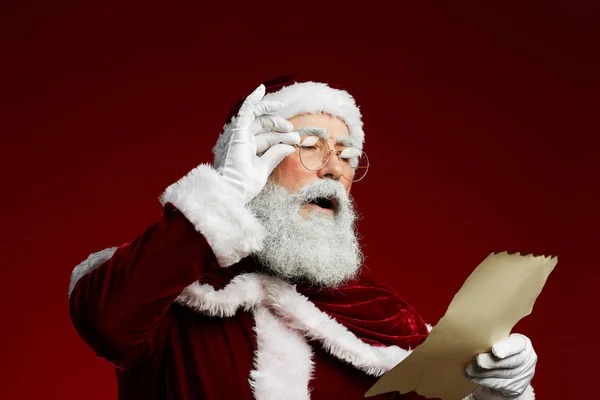 Klasik Noel Baba Okuma Listesinin Belden Yukarı Portresi Kırmızı Arka — Stok fotoğraf