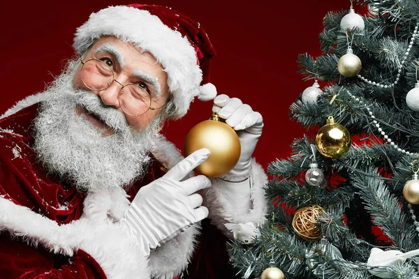 Porträtt Glada Santa Håller Gyllene Prydnad När Står Vid Julgran — Stockfoto