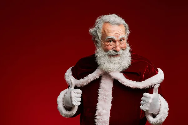 提起快乐圣诞老人的画像 在红色背景下竖起大拇指 复制空间 — 图库照片