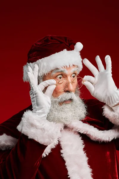 Портрет Здивованого Санта Клауса Який Дивиться Вправо Коригує Окуляри Ставлячи — стокове фото