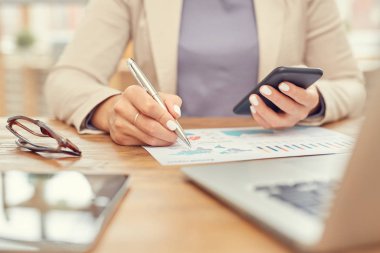 İş yerinde akıllı telefon kullanırken, iş yerinde çalışan kadınları işaret eden kadın eliyle ilgili verileri analiz eden tanınmayan iş kadınlarını kapatın.