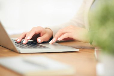 Ofiste çalışırken dizüstü bilgisayar kullanan tanınmayan bir iş kadınını kapat, klavyede yazan kadın ellerine odaklan, boşluğu kopyala