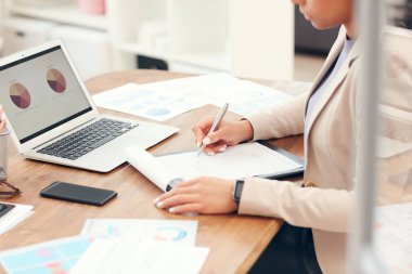 Modern ofiste masa başında çalışırken panoya yazı yazan başarılı bir iş kadınının kırpılmış portresi.