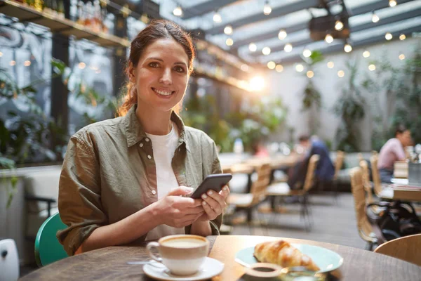 Retrato Una Hermosa Mujer Joven Sonriendo Cámara Mientras Usa Teléfono —  Fotos de Stock