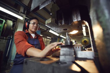 Endüstriyel fabrikadaki modern Afro-Amerikalı kadın işletim makinelerinin düşük açılı portresi, kopyalama alanı