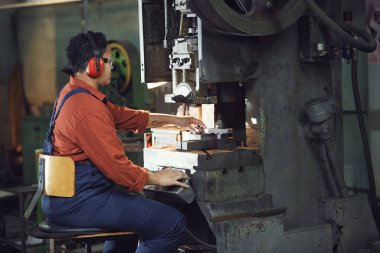 Endüstriyel fabrikadaki Afro-Amerikalı kadın işletim makinelerinin yan görünüş portresi, kopyalama alanı