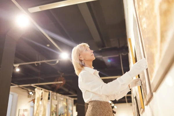 Laaghoekig Portret Van Elegante Volwassen Vrouw Hangende Schilderijen Tijdens Het — Stockfoto