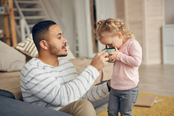 Zijaanzicht Portret Van Zorgzame Vader Helpen Schattig Dochtertje Drinken Uit — Stockfoto