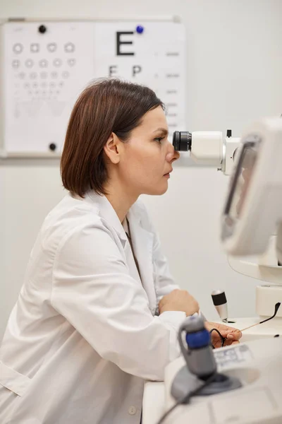 Zijaanzicht Portret Van Jonge Vrouwelijke Oogarts Met Behulp Van Refractometer — Stockfoto