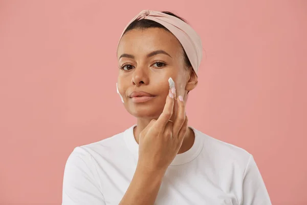 Retrato Una Hermosa Mujer Joven Que Aplica Crema Facial Mira —  Fotos de Stock