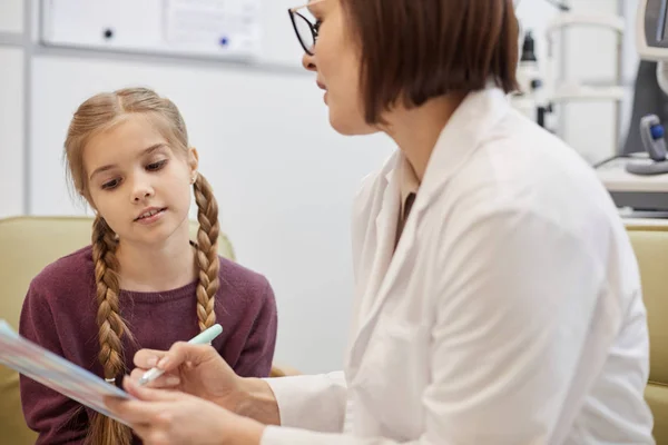 Retrato Linda Chica Mirando Portapapeles Durante Consulta Con Médico Clínica — Foto de Stock