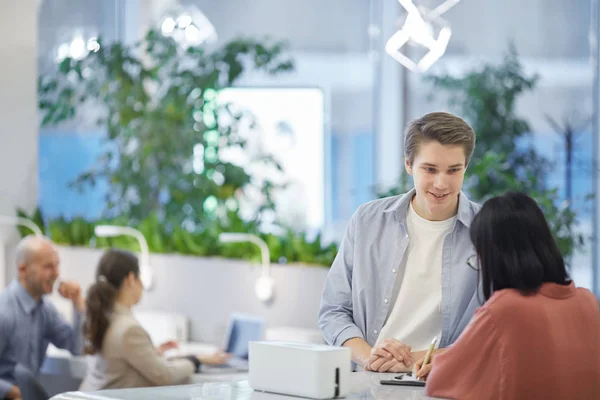 Retrato Joven Hablando Con Amigo Asiático Mientras Está Pie Escritorio — Foto de Stock