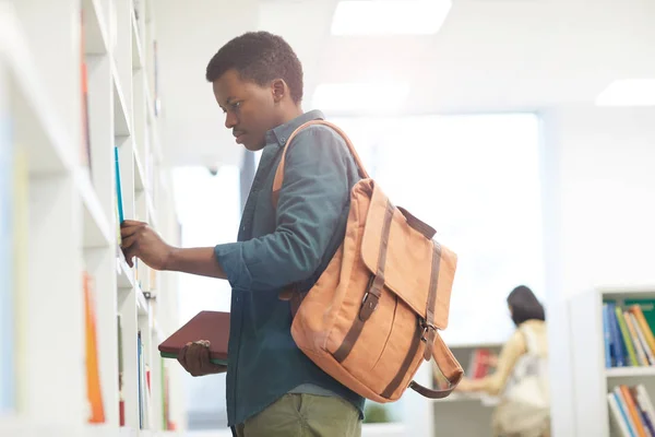 Side View Portrait African Student Wearing Backpack Choosing Books Shelves — Stock Photo, Image