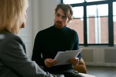Güzel sakallı adamın belden yukarı portresi. Ofis içi işleri tartışırken kadın partnerle konuşuyor. Kopya alanı.