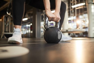 Modern spor salonundaki güç egzersizi sırasında dambılları kaldıran, tanınmayan genç bir kadının dambıllarını kaldıran, modern spor salonundaki güç egzersizleri sırasında kaldıran, uzay boşluğunu kopyalayan,