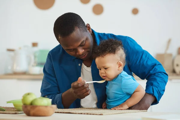Retrato Papá Afro Americano Feliz Alimentando Lindo Niño Blanco Sentado —  Fotos de Stock
