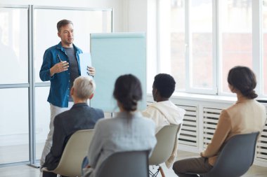 Seminer sırasında izleyicilere konuşma yapan olgun bir adamın portresi, kopyalama alanı