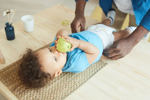 認識できない父での高い角度ビューおむつをかわいいアフリカ系アメリカ人の幼児にアップルを食べます コピースペース — ストック写真