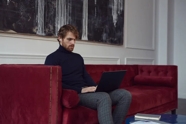 Retrato Homem Barbudo Bonito Usando Laptop Enquanto Sentado Sofá Veludo — Fotografia de Stock
