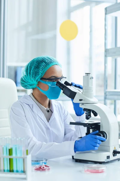 医学实验室研究中女性科学家在显微镜下的侧视图画像 — 图库照片