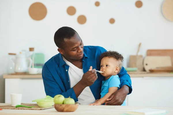 Retrato Papá Afroamericano Feliz Alimentando Lindo Niño Blanco Sentado Mesa —  Fotos de Stock