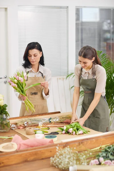 Vertikalt Porträtt Två Unga Kvinnor Som Arrangerar Tulpanbuketter Och Blomsterkompositioner — Stockfoto