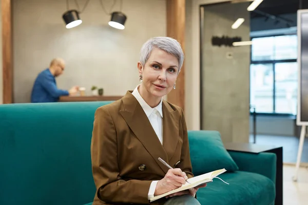 Portrait Elegant Mature Businesswoman Writing Note Book Looking Camera While — Stock Photo, Image