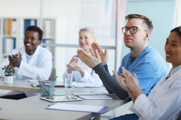 Orvosok Többnemzetiségű Csoportja Tapsol Miközben Orvosi Konferencia Alatt Asztalnál Ülnek — Stock Fotó