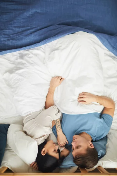 上のビューで現代の若いカップルで一緒に眠っている青とベッドシーツながら コピースペース — ストック写真