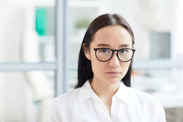 年轻的亚洲女商人头像和肩像 戴着眼镜 站在现代的白色办公室里看着相机 复制空间 — 图库照片