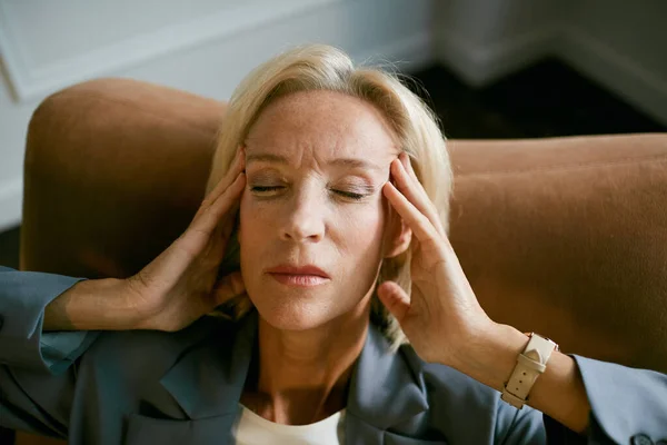 Portrait Stressed Mature Businesswoman Rubbing Temples Suffering Headache While Sitting — Stock Photo, Image