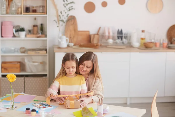 Retrato Cálido Madre Feliz Abrazando Hija Mientras Abre Regalos Mesa — Foto de Stock