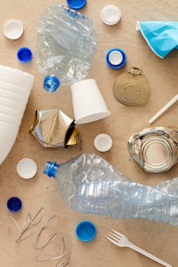 Karton arka plan, atık sıralama ve geri dönüşüm konsepti üzerinde minimum kompozisyonda bulunan çeşitli çöp ögelerinin görünümünün üzerinde, boşluk kopyala