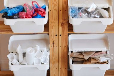 Evdeki atık ayıklama için dört plastik çöp kutusuyla ahşap rafların arkaplan görüntüsü, geri dönüşüm için hazırlanma, kopyalama alanı