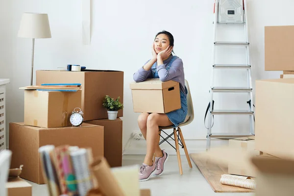 移動や移転の乗組員を待っている間 空の部屋に椅子に座って段ボール箱を保持若いアジアの女性の完全な長さの肖像画 スペースをコピー — ストック写真