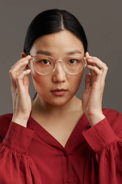 Stüdyoda Gri Arka Planda Dururken Gözlük Takan Zarif Asyalı Kadının — Stok fotoğraf