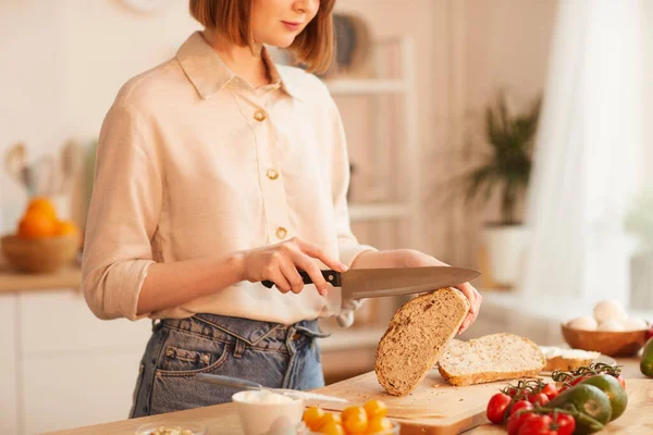 Mitten Avsnitt Porträtt Modern Ung Kvinna Skära Färska Fullkornsbröd Samtidigt — Stockfoto