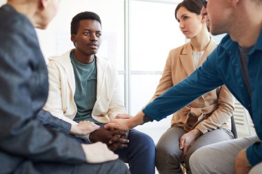 Çok ırklı bir grup insan el ele tutuşurken, Afro-Amerikan gençleri destek grubunda rahatlatıyor, boşluğu kopyalıyor.