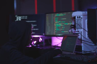 Tanımlanamayan hacker portresi bilgisayar donanımı kullanıyor, programlama kodu kullanıyor karanlık odadaki ekranlarda, siber güvenlik konsepti, kopyalama alanı