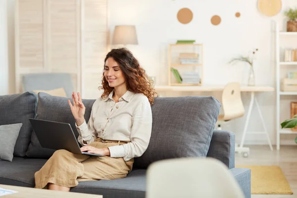 Mujer Joven Adulta Sentada Sofá Casa Participando Una Videoconferencia Saludando — Foto de Stock