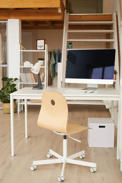 Vertical image of contemporary two level apartment interior with home office workplace in foreground, copy space