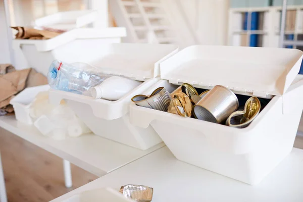 Background image of various trash items sorted by material type and ready for recycling in office interior, focus on metal cans in foreground, copy space