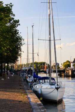 Gün batımı sırasında Hollanda'da sakin bir limanında Yelkenliler