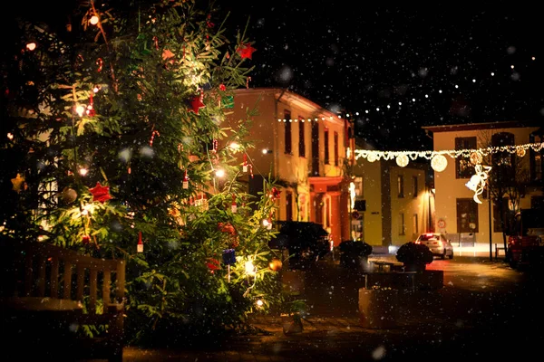 Kar yağışı sırasında romantik, ışıklı Noel ağacı